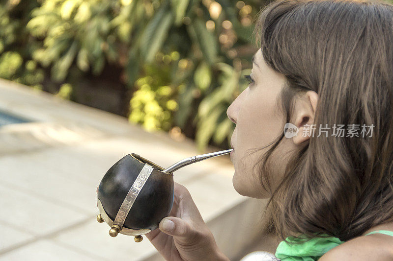 Woman about to drink a "Mate", a popular infusion in Argentina, Brazil, Paraguay and Uruguay, made with Yerba Mate.